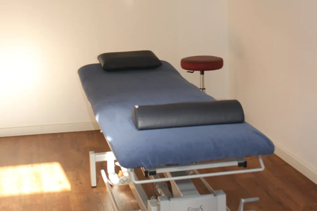 Höhenverstellbare Therapieliege in einem Behandlungsraum der Praxis
