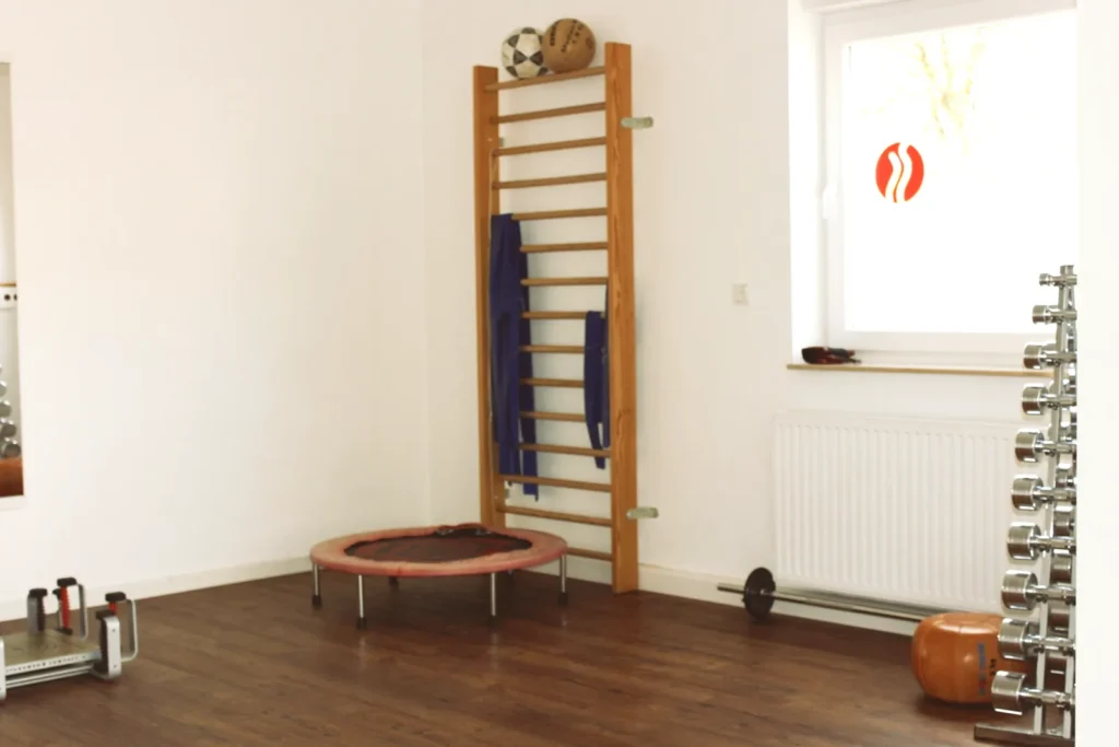 Trainingsfläche mit Sprossenwand, Trampolin und Hanteln